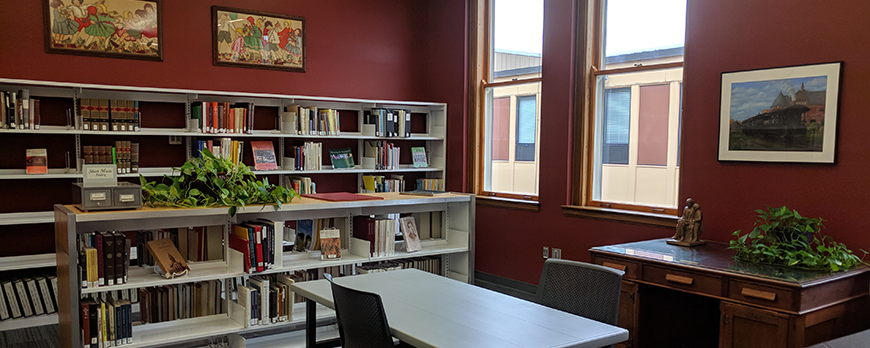 Heritage Room filled with books, two desks, and historical artwork